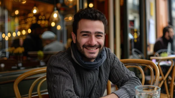 Man smiling sitting in a French Cafe