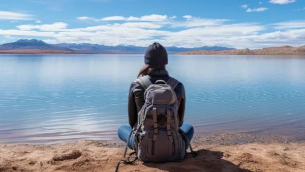 Woman sitting at the edge of a lake enjoying a digital detox